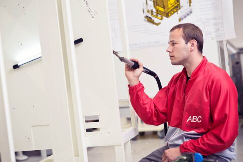 Ein junger Mann schweißt Kunststoffplatten mit einem Heißluftfön